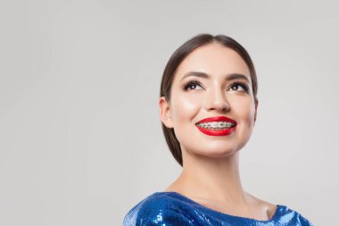 Diş telleri beyaz arka planda gülümseyen çekici bir kadın.