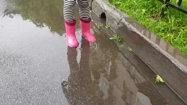 Criança Salta Alegria Uma Poça Após Chuva — Vídeo de Stock