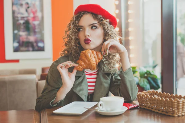 きれいな女性はコーヒーを飲み ヨーロッパの街のカフェでフランスのクロワッサンを食べる — ストック写真