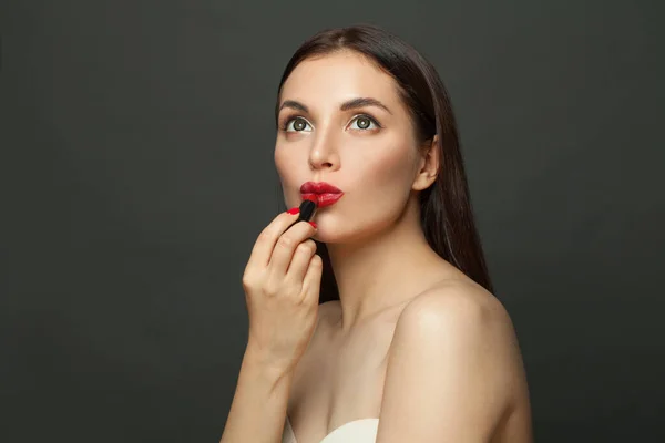 Mulher Jovem Aplicando Maquiagem Batom Vermelho Lábios Fundo Preto — Fotografia de Stock
