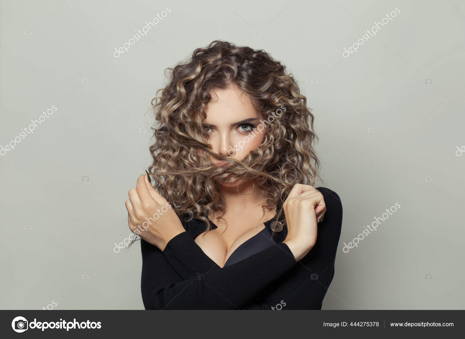 Pretty Woman Curly Hairstyle Touching Her Hair White Background Stock Photo  by ©Artmim 444275378