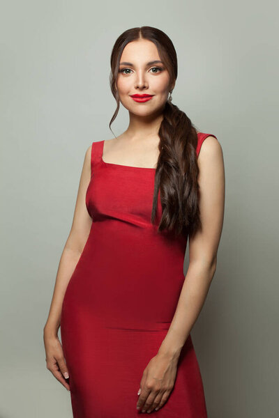 Fashion model woman in red dress standing on white background