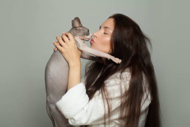 Gri arka planda çekici kadın ve sfenks kedisi.