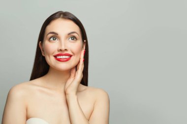 Esmer model kadın, beyaz arka planda uzun ve sağlıklı saçları var. Cilt bakımı ve yüz tedavisi kavramı