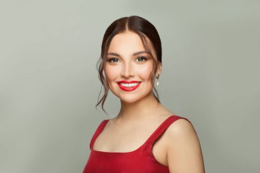 Beyaz arka planda gülümseyen esmer kadın.