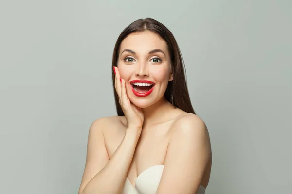 Beautiful surprised woman with clear skin on white background