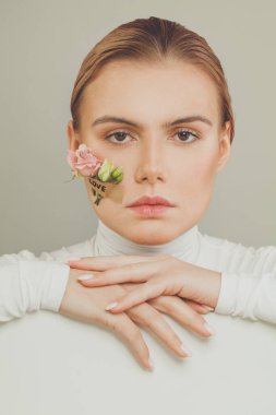 Aşk yazıtlı çekici bir kadın ve beyaz pankartlı bahar çiçekleri.