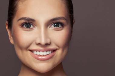 Güzel, genç bir bayanın yakın plan portresi. Sağlıklı model kadın gülümsüyor