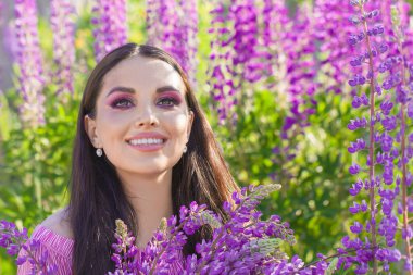 Dışarıda elinde renkli çiçekler tutan sevimli genç bir bayan.