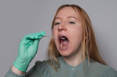 Ağzı açık bir kadın Coronavirus test kiti kullanıyor. Tıp, sağlık ve Covid-19 konsepti