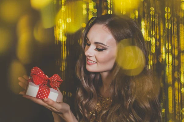 Hermosa Mujer Sosteniendo Regalo Sobre Fondo Bokeh Dorado — Foto de Stock