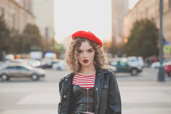 素敵な若い女性を身に着けているストライプTシャツ 黒ジャケットと赤ベレー帽ポージング上の通り — ストック写真