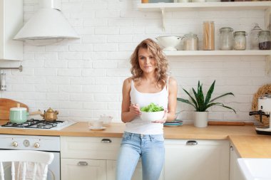 Sebze salatası yiyen neşeli bir kadın. Sağlıklı yaşam tarzı, diyet ve sağlıklı beslenme konsepti