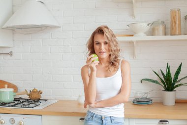 Ev mutfağında yeşil elmalı sağlıklı bir kadın.