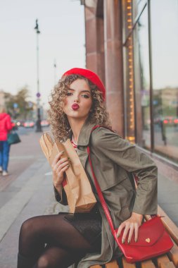 Kırmızı çantalı ve açık havada Fransız beresi takan hoş bir genç bayan.