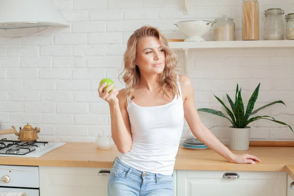 Söt Ung Kvinna Som Håller Grönt Äpple Och Ler Hemma — Stockfoto