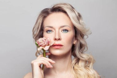 Olgun güzellik. Gri bir arkaplana karşı poz veren sağlıklı tenli güzel bir kadının yakın çekim stüdyosu. Kadın cilt bakımı resmi