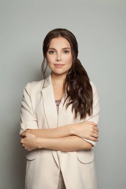 Beyaz arka planda duran çapraz kollu iş kadını.