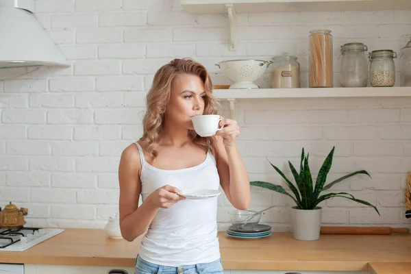 可愛いですカジュアルな女性飲むコーヒーに家 — ストック写真