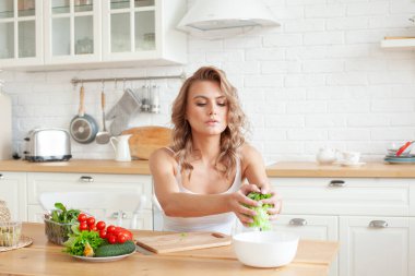 Genç bir kadın yemek yapıyor. Sağlıklı sebze salatası. Diyet olsun. Diyet konsepti. Sağlıklı bir yaşam tarzı. Evde yemek pişirmek. Yemek hazırlayın.