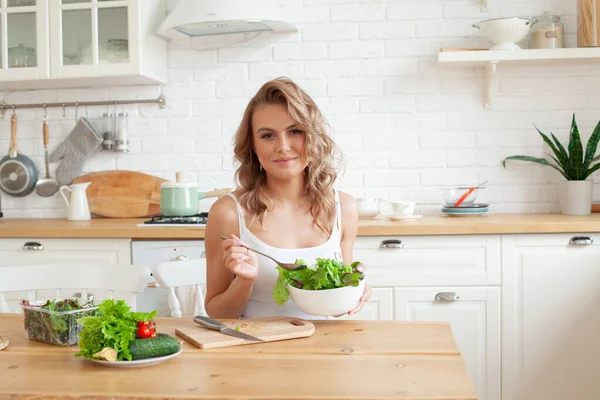 Salata yiyen bir kadın. Güzel, sağlıklı, gülümseyen kadın taze, sağlıklı salatanın tadını çıkarıyor.