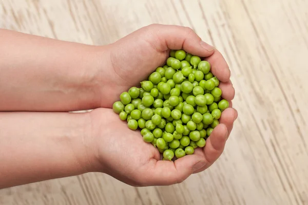 Grüne Erbsen Den Händen Auf Hölzernem Hintergrund — Stockfoto