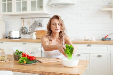 Evde karışık sebzeli güzel bir kadın var. Sebze hazırlayan kadın