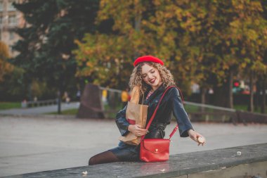 Açık havada kırmızı bereli mutlu bir kadın.