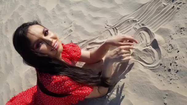 Jolie Fille Couchée Sur Plage Dessinant Forme Cœur Dans Sable — Video