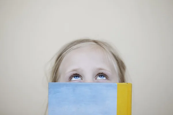 Девушка с книгой смотрит вверх — стоковое фото