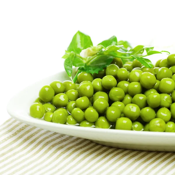 Guisantes verdes en el plato, fondo ingrediente alimentario — Foto de Stock