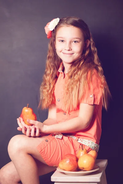 Bambina che tiene il frutto della pera tra le mani — Foto Stock