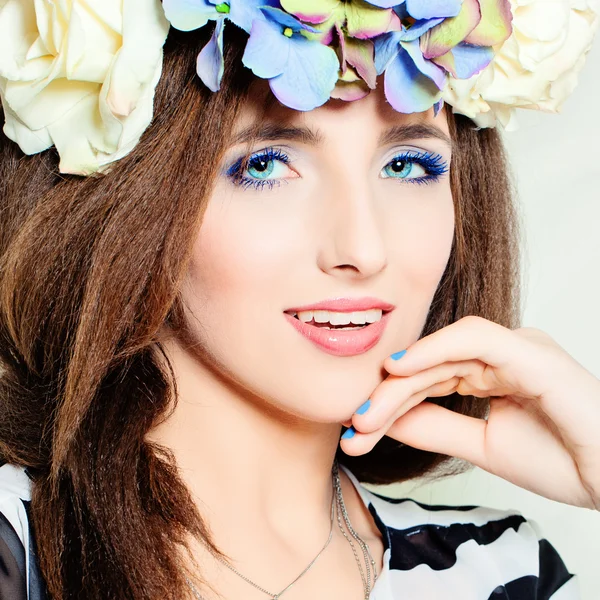 Nette Frau. schönes blaues Make-up. Haare mit Sommerblumen — Stockfoto