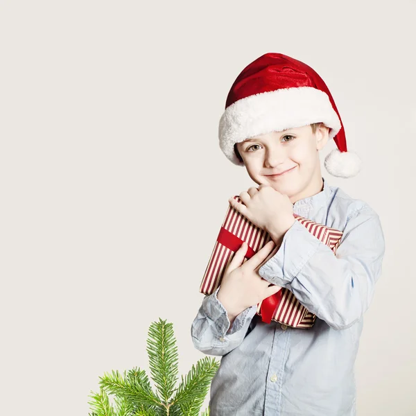 Joyeux enfant étreinte boîte cadeau de Noël. Concept de bonheur de Noël — Photo