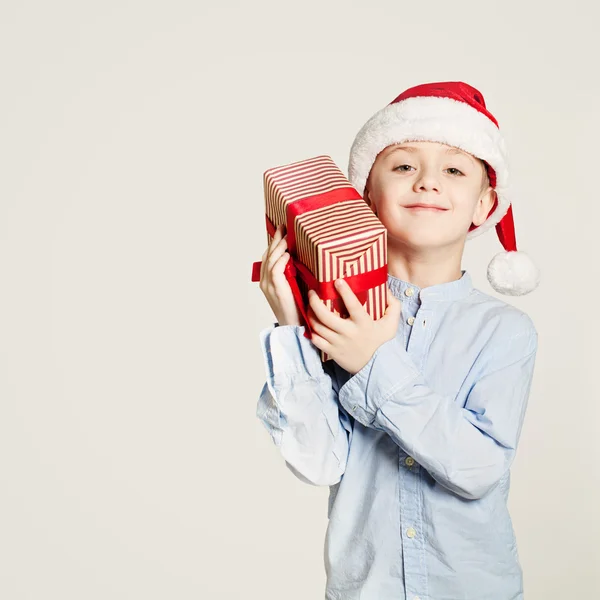 Enfant tenant boîte cadeau de Noël. Enfant garçon et cadeau sur fond — Photo