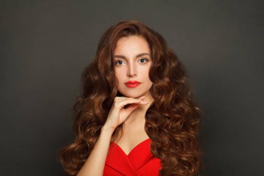 Nice woman with long hair and make-up on black background. Gorgeous woman with curly hairstyle