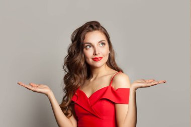 Sağlıklı model kadın boş avuç içini tutuyor ve beyaz arka plana bakıyor.