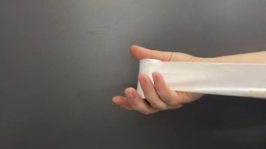 Yapay ipek kurdele çözülüyor, ovuluyor, hışırdıyor.