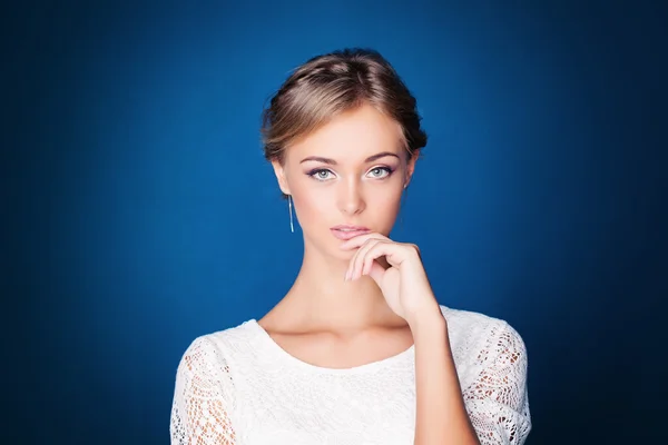 Giovane donna pensierosa su sfondo blu — Foto Stock