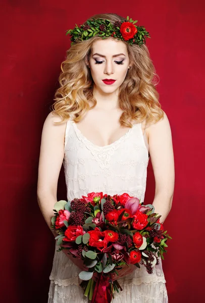 Krásná snoubenka v bílé šaty a květiny na červeném pozadí — Stock fotografie