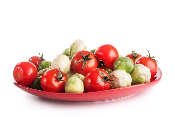 Legumes na placa vermelha — Fotografia de Stock