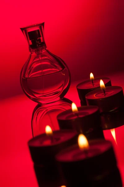 Velas ardientes y frasco de perfume — Foto de Stock