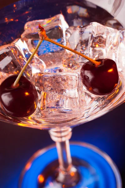 Martini-Glas mit Eis und Kirschen Stockbild
