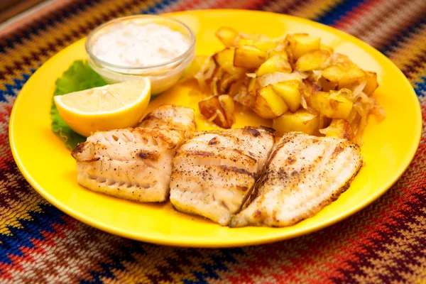 Der Barschfischgrill mit Kartoffeln und Zitrone und Sauce — Stockfoto
