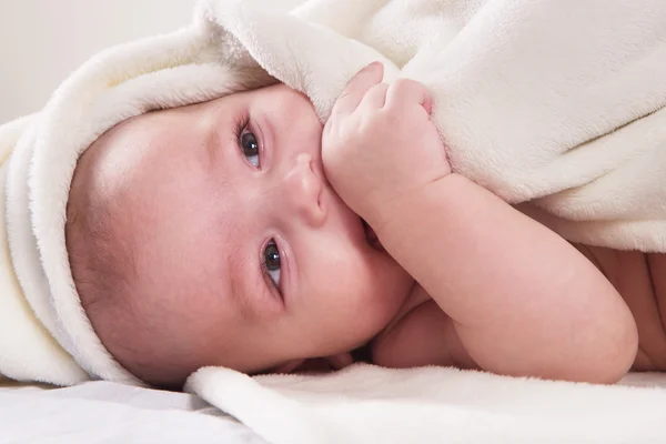 Il bambino sdraiato su un asciugamano bianco — Foto Stock