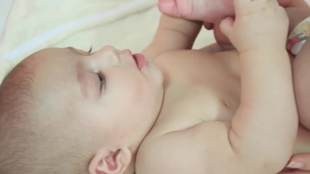 Bebê tenta tocar o dedo do pé — Vídeo de Stock