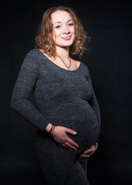 Hamile bir kadın farklı pozisyonlarda bir stüdyoda fotoğraf çekimi