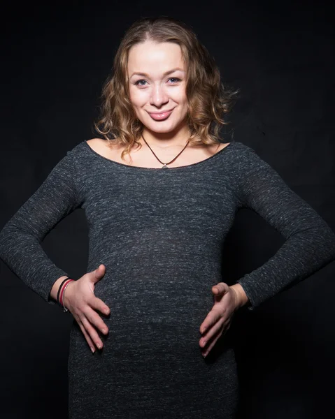 Fotograferen van een zwangere vrouw in een studio in verschillende posities — Stockfoto