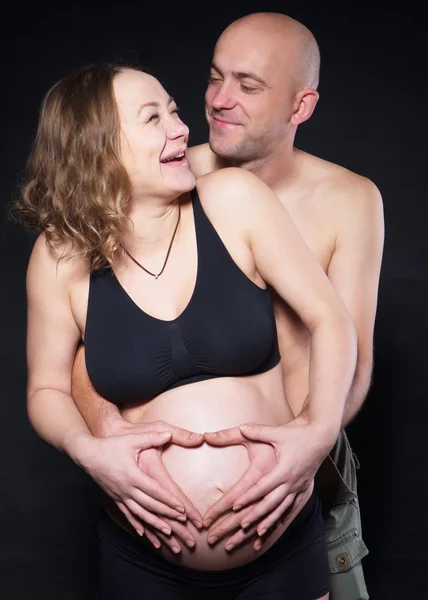 Photographie femme enceinte avec son mari la serrant par derrière — Photo