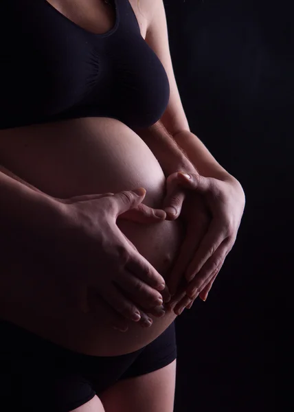 Photographie femme enceinte avec son mari la serrant par derrière — Photo